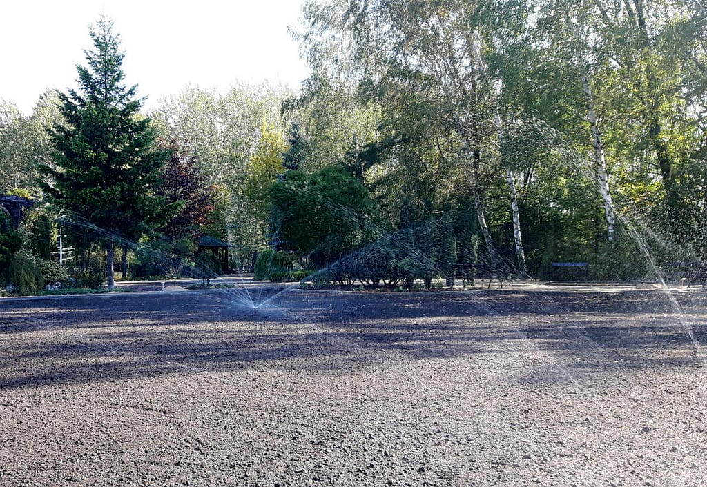 Nowy trawnik nawadniany zraszaczami rotacyjnymi